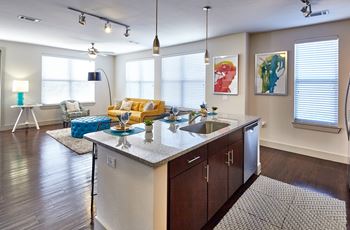 A modern kitchen with a large island and a dining area.at Century Cedar Hill, Cedar Hill